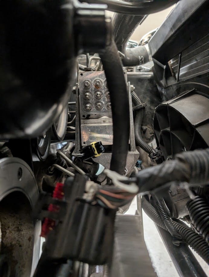 A picture of the ABS block on a C5 Corvette with the EBCM removed, as viewed from behind the radiator.