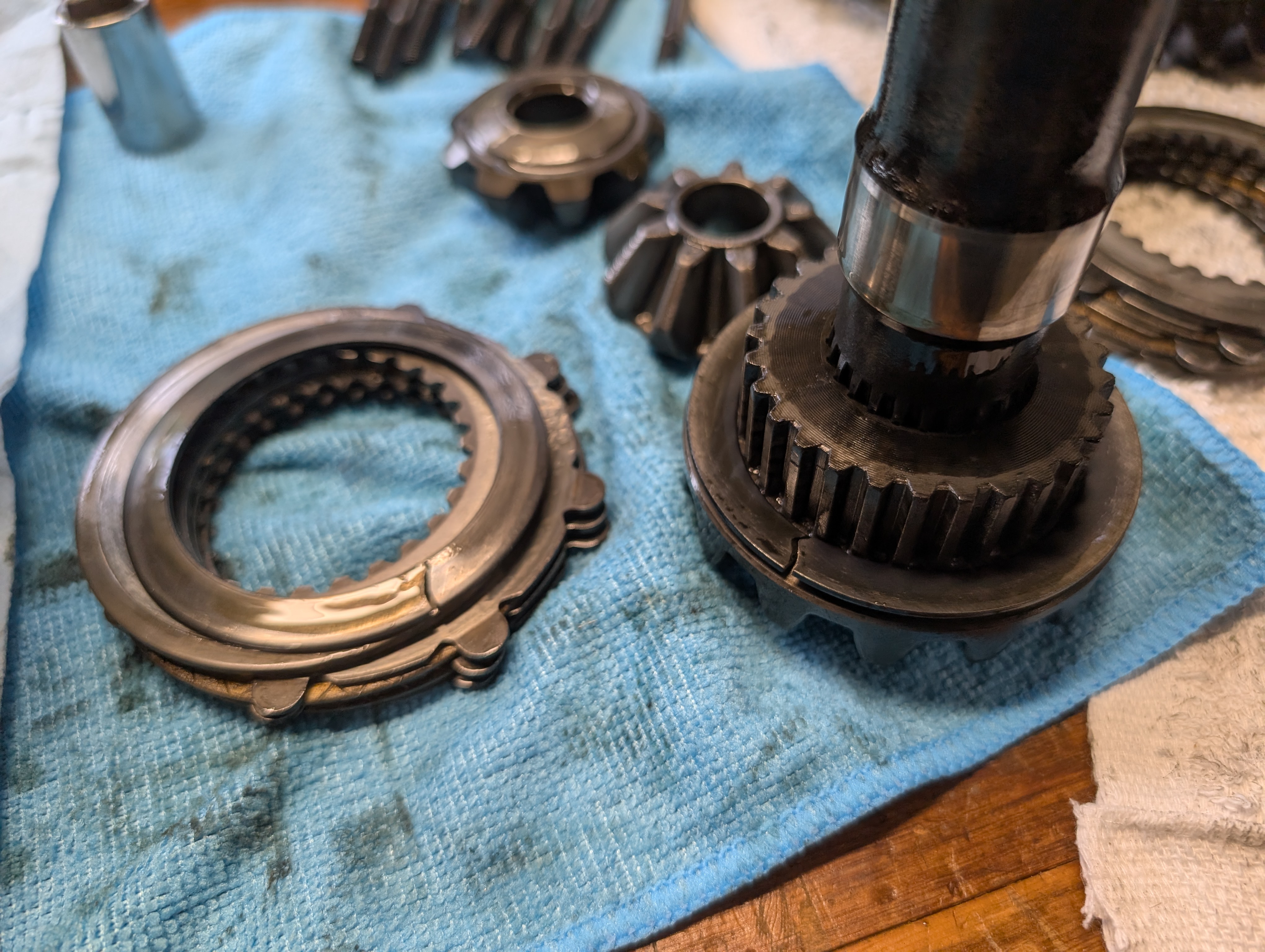 An axle shaft in a partially disassembled C5 Corvette differential, showcasing damaged clutch packs.