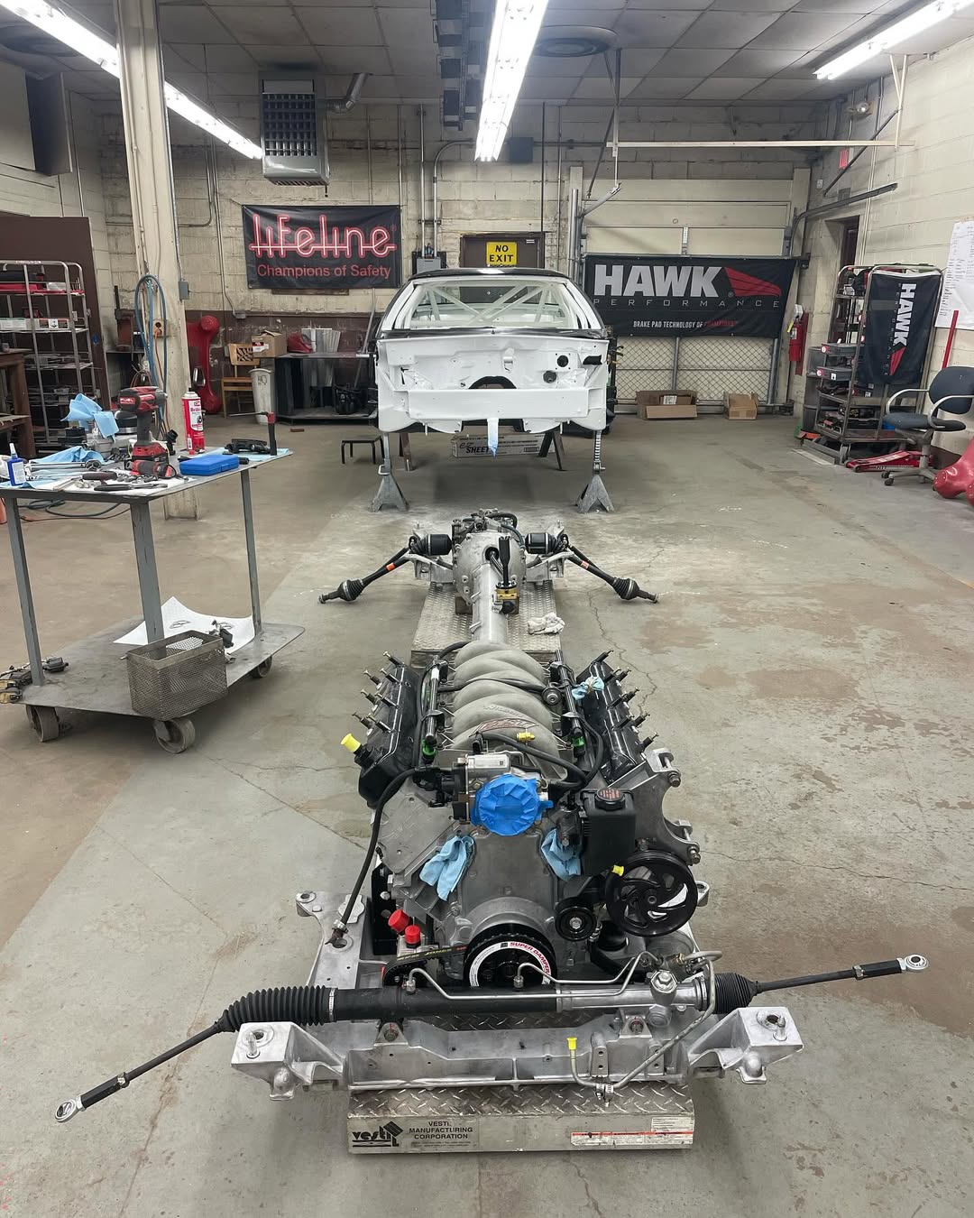 A stripped down C5 Corvette with its full drivetrain out on the shop floor