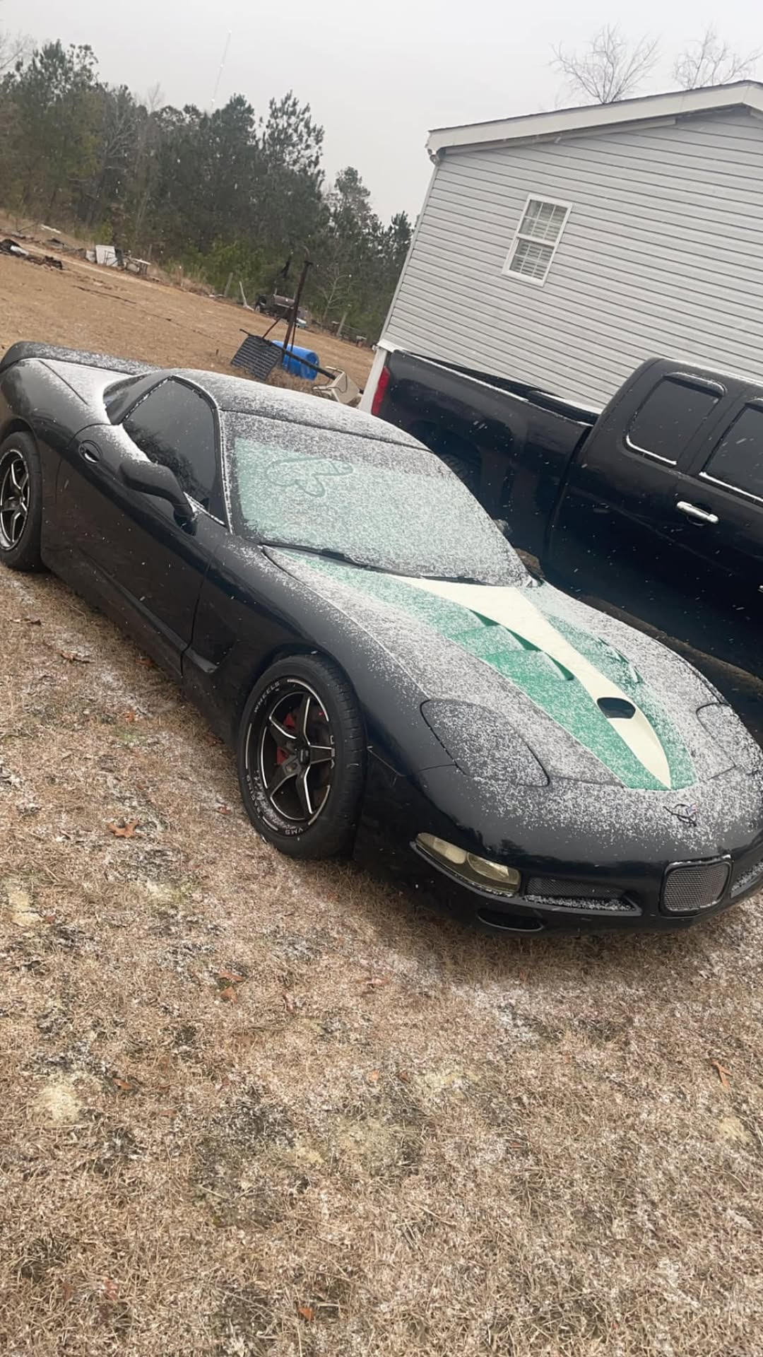 A snow covered C5 Corvette with a funny drawing on the windshield