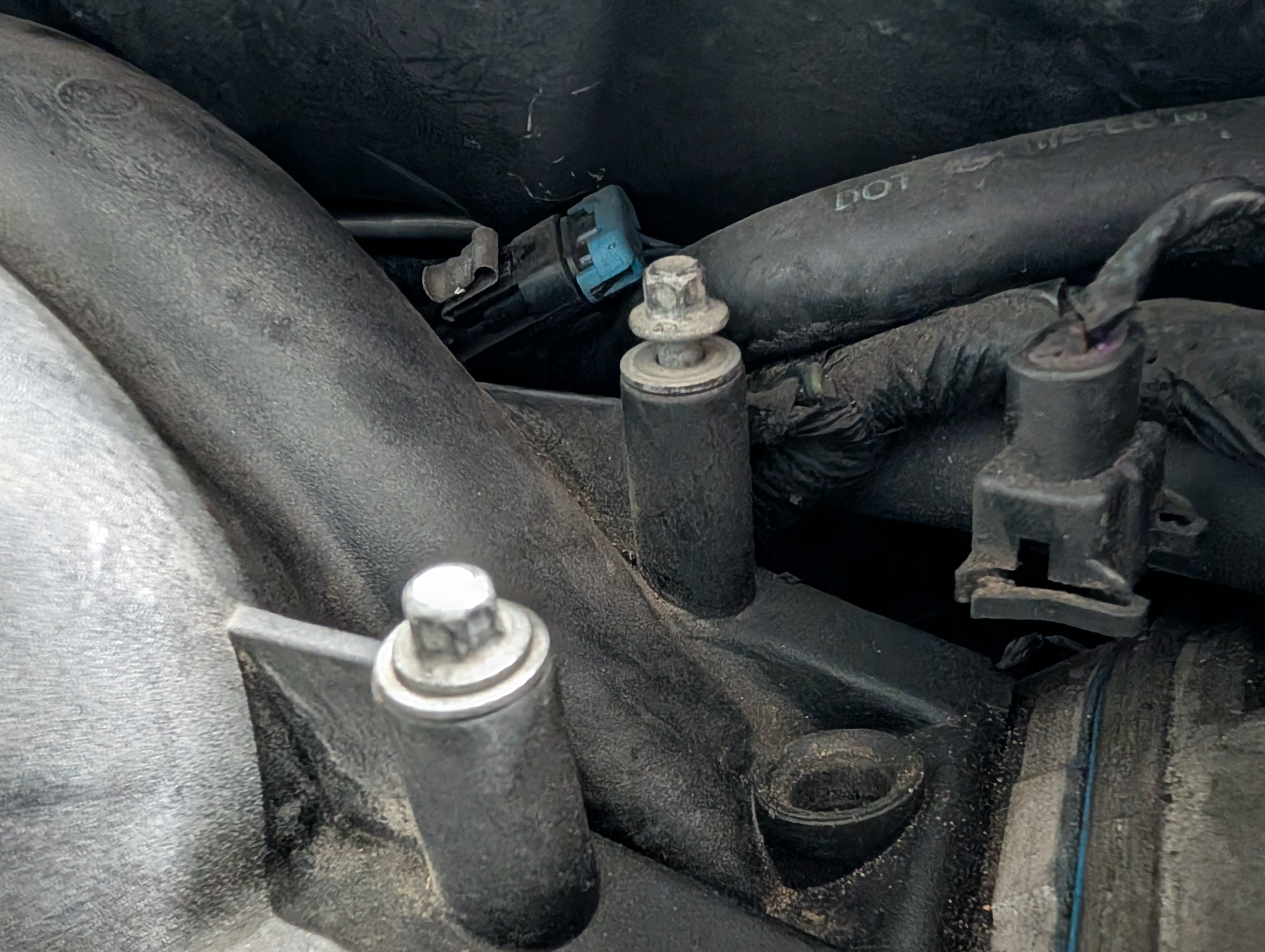 The rear drivers side intake manifold bolt, lifted about a half inch above where it should be when snugged down.