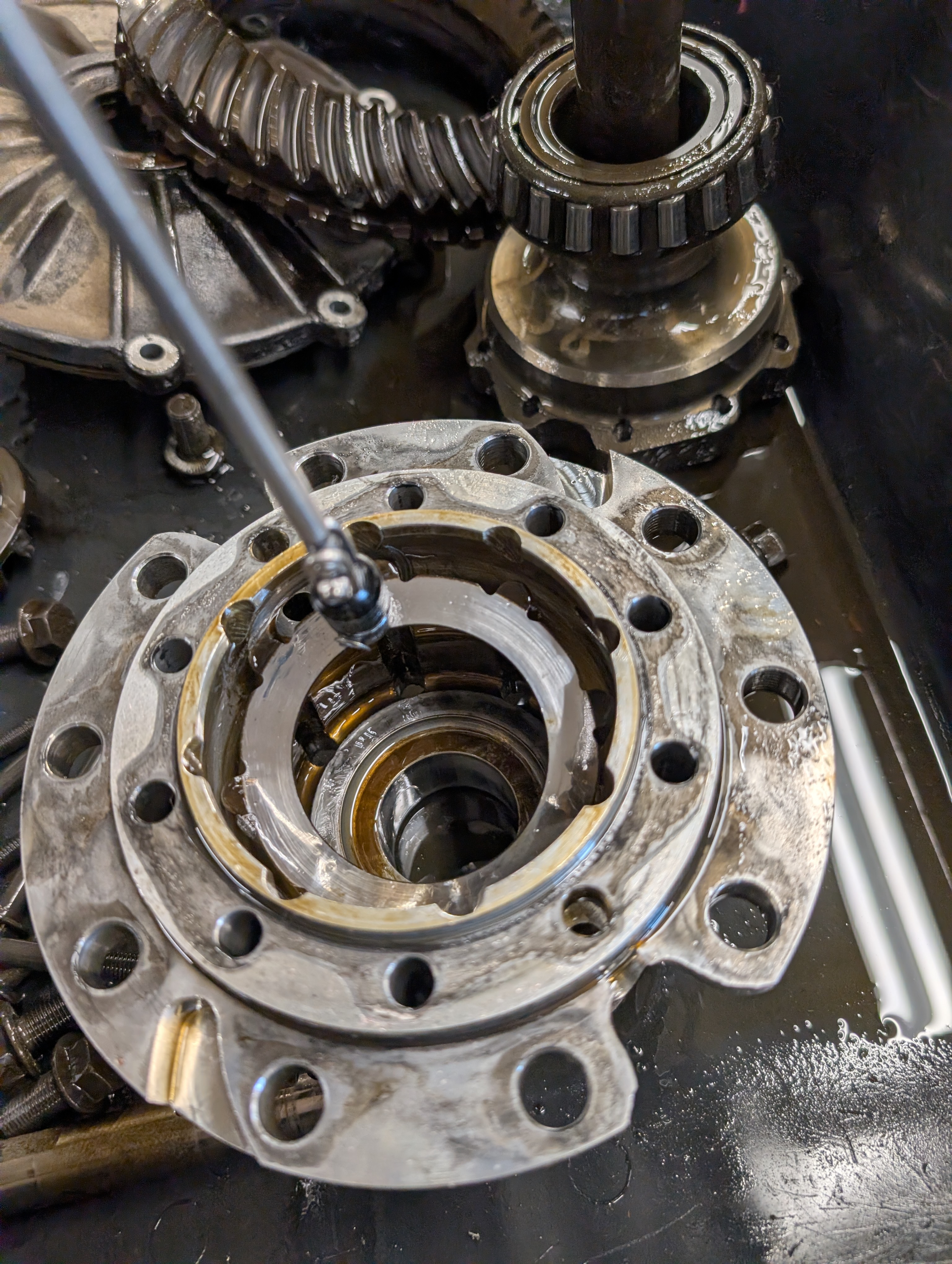 A magnet tool being used to remove the bottom part of a clutch pack from a C5 Corvette differential center case / carrier