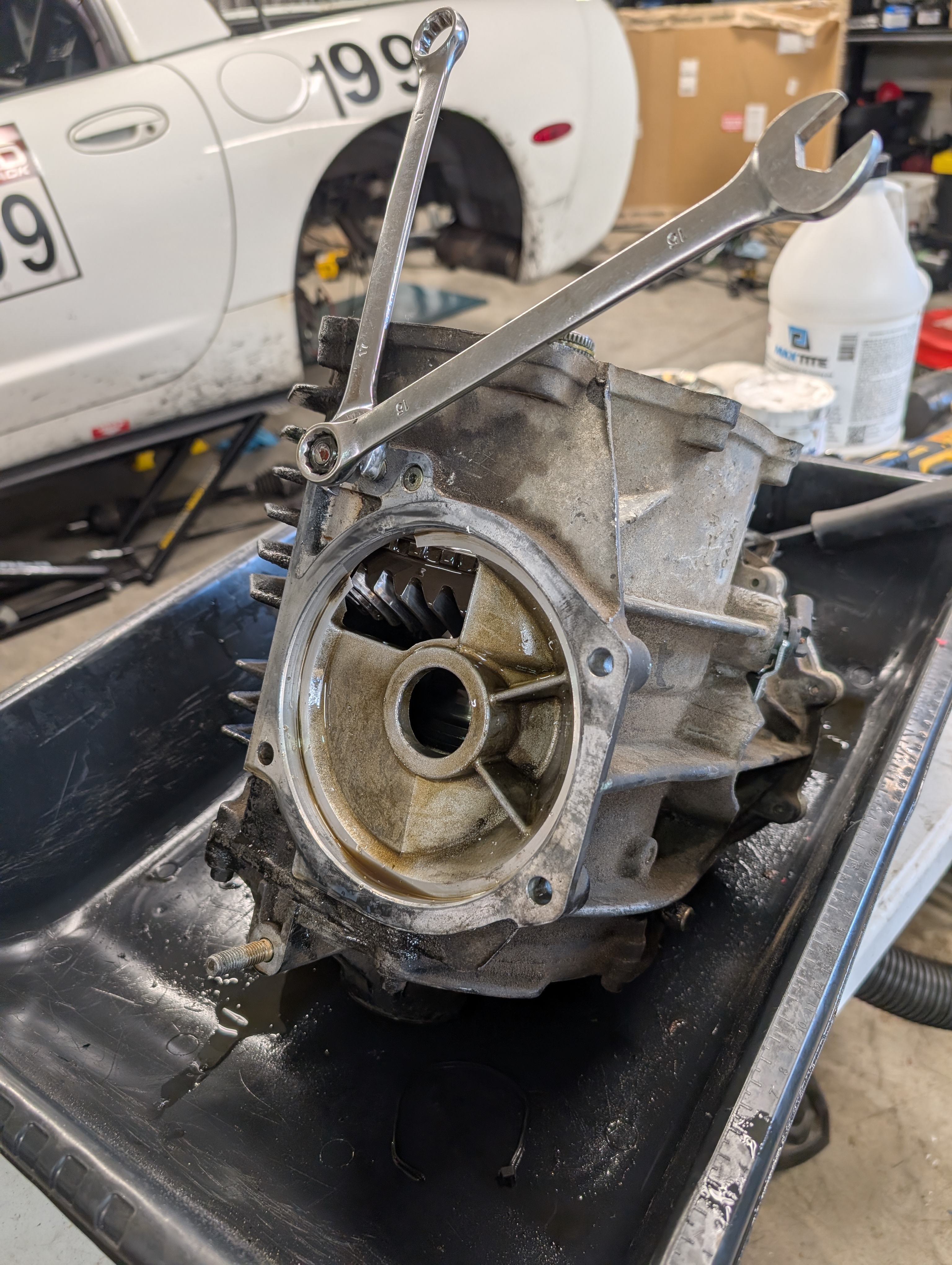 A c5 Corvette differential being torn apart, with two wrenches and sandwhiched nuts being used to remove a mounting stud that blocks the removal of the diff internals