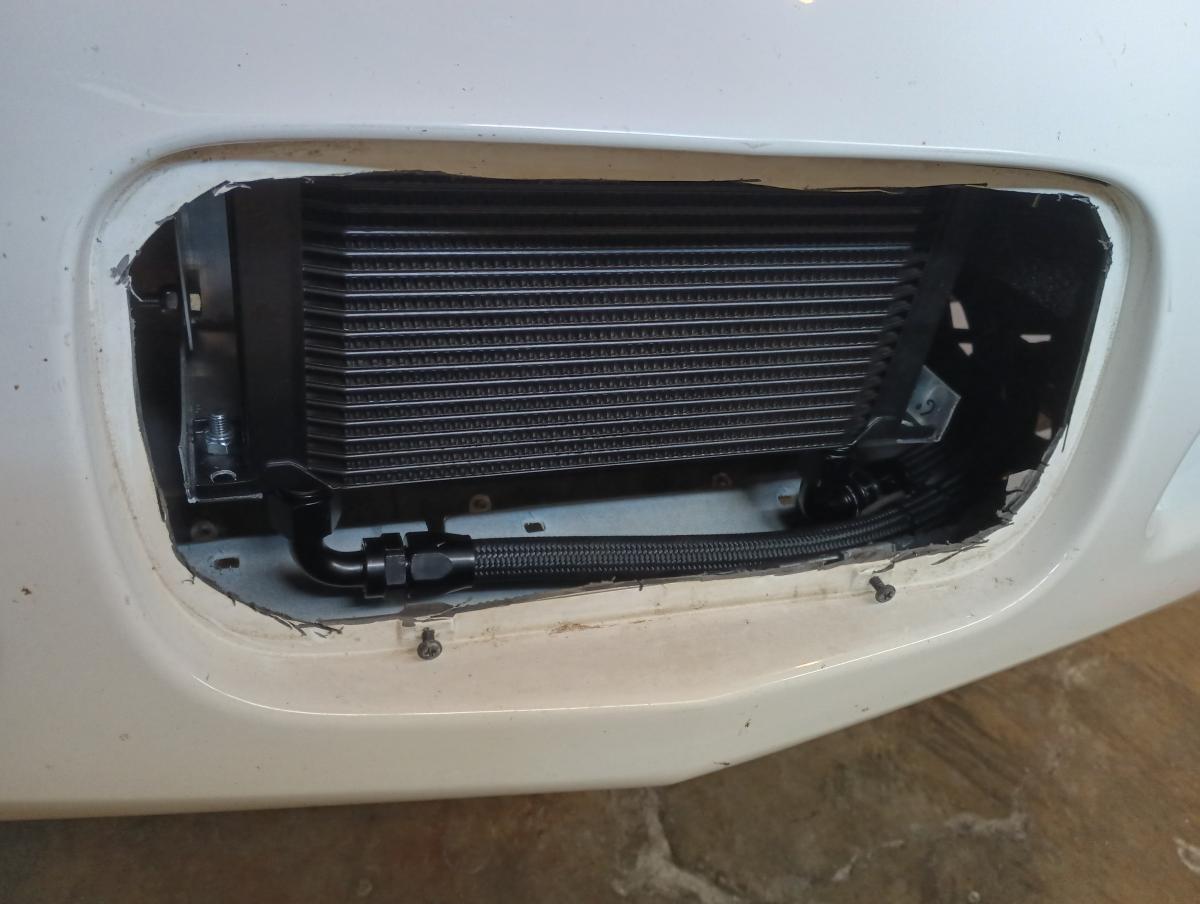 A C5 Corvette front license plate area removed, with an oil cooler installed behind it.