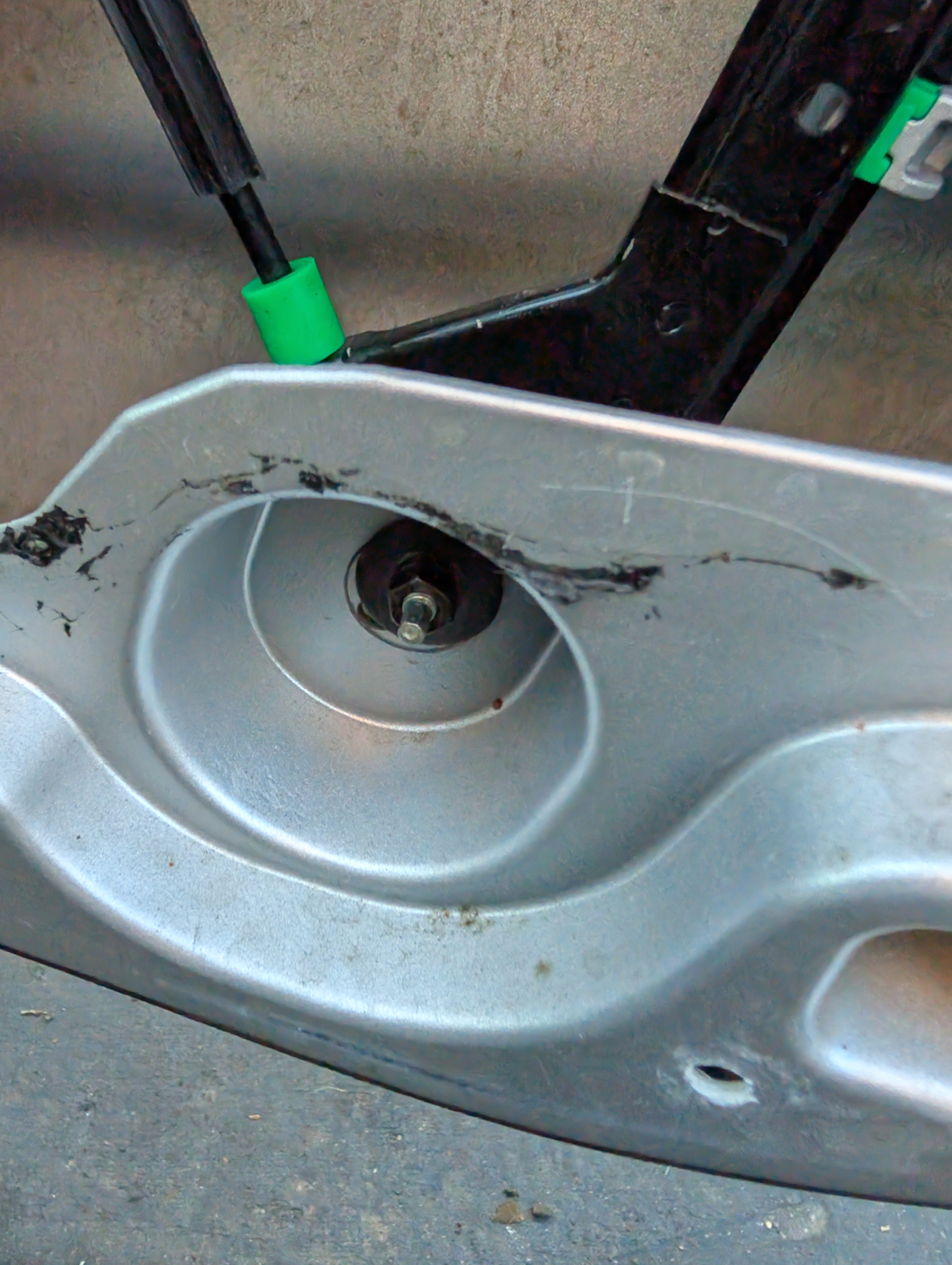 The bow adjustment mechanism on the inside of a C5 Corvette door.