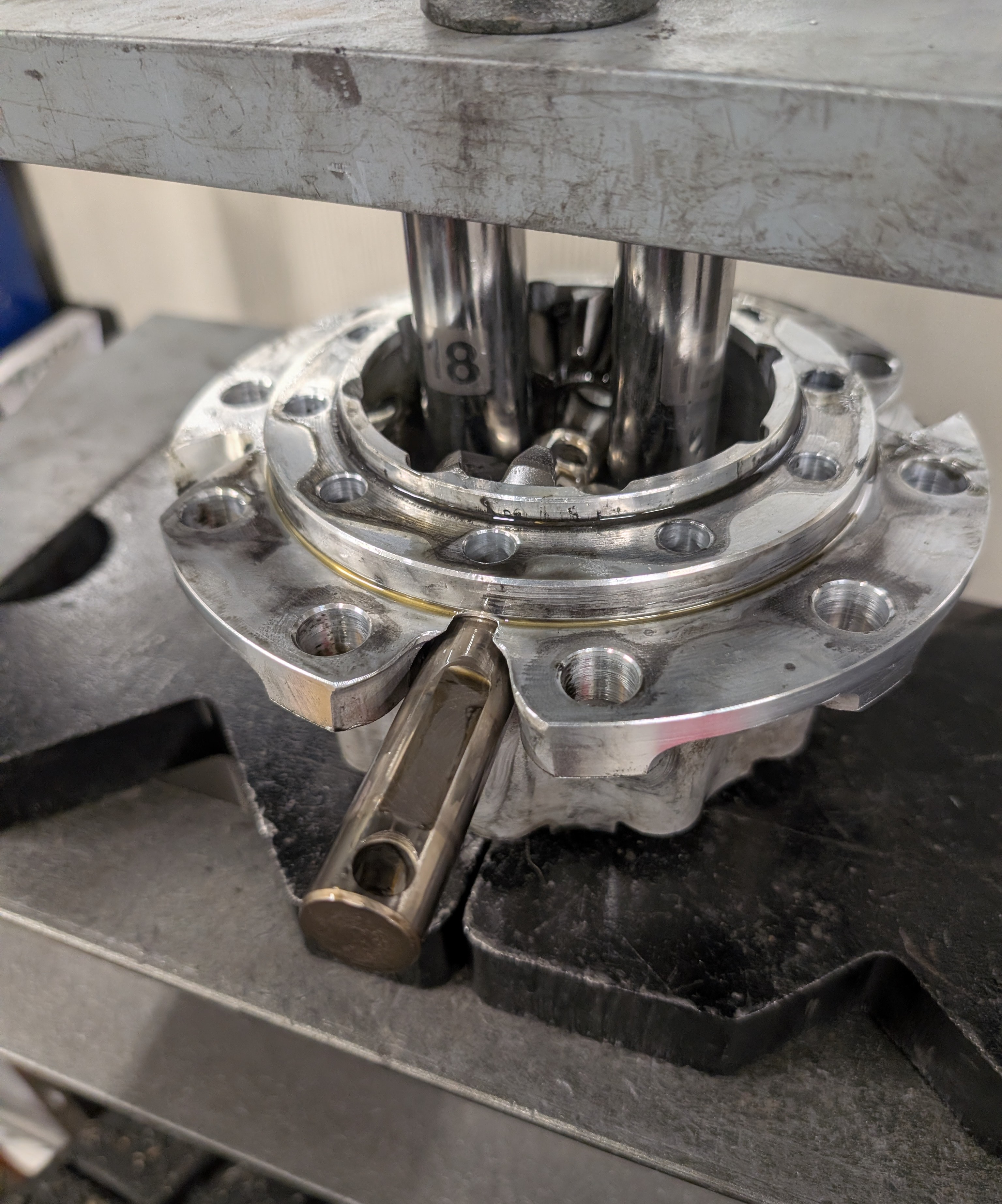A shop press being utilized to apply pressure to the shim stack of a C5 Corvette differential center carrier, allowing for removal of the counter shaft holding in the side gears and preventing clutch pack removal