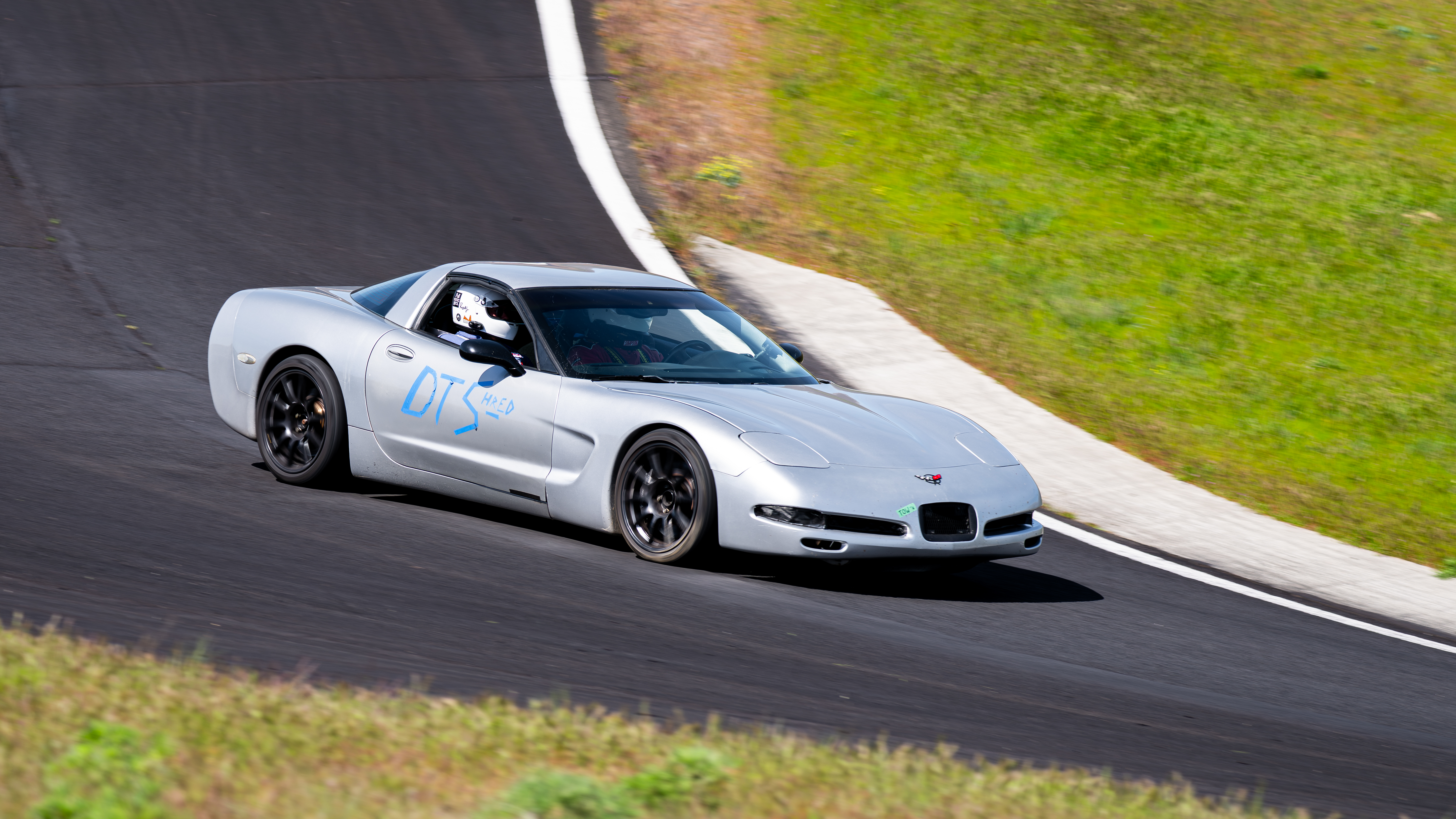 The Dead to Shred Corvette mid corner, with a passenger helmet visible as there were two people in the car at this time.