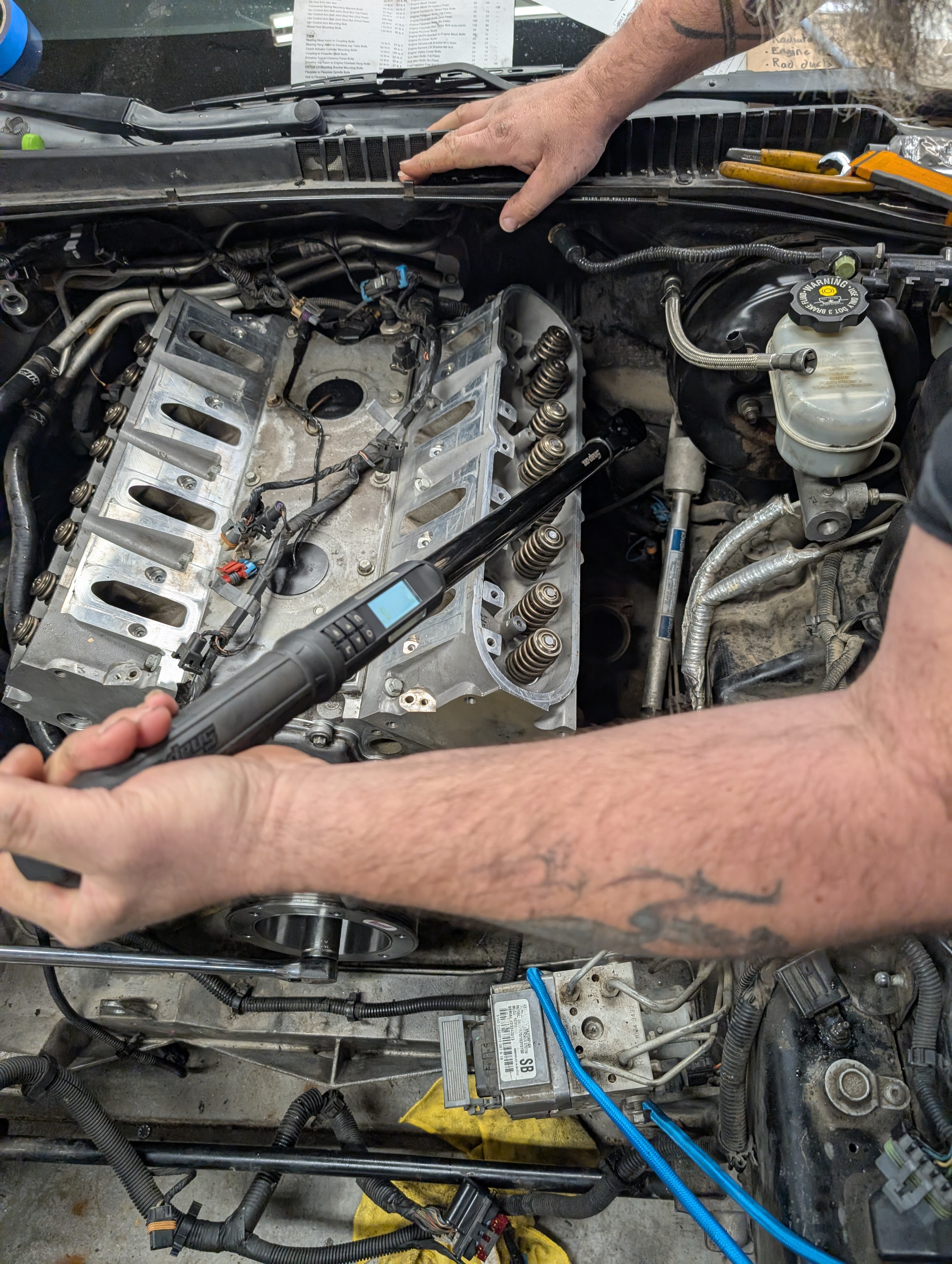 Tightening the LS1 head bolts with the torque meter, featuring Dave's left arm.