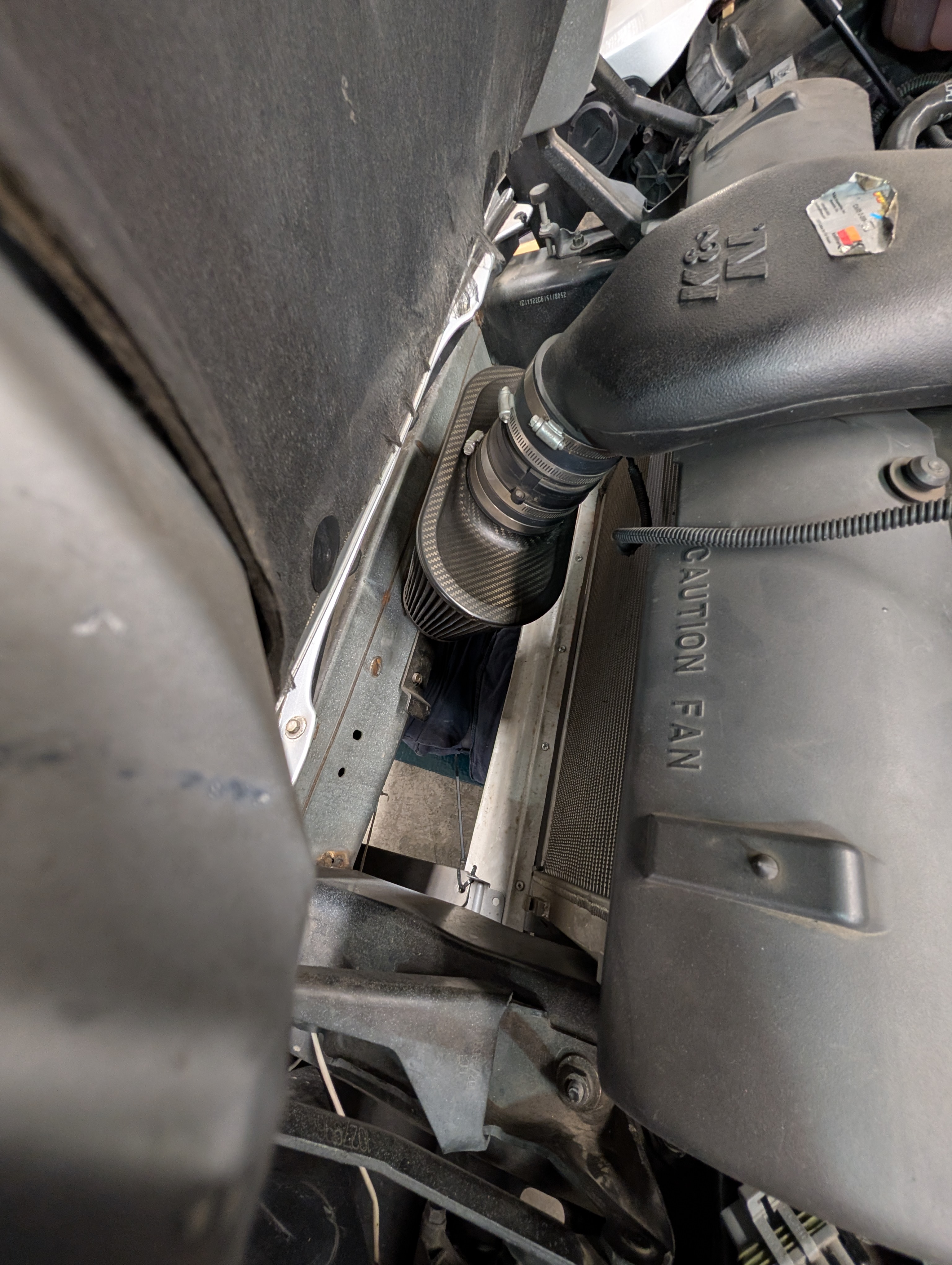 The front of the radiator with the air intake hanging down. The radiator duct is clearly missing as you can see through where it would be straight to the floor.