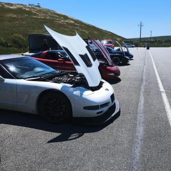 C5 Corvettes lined up At Thunderhill West with their hoods open.